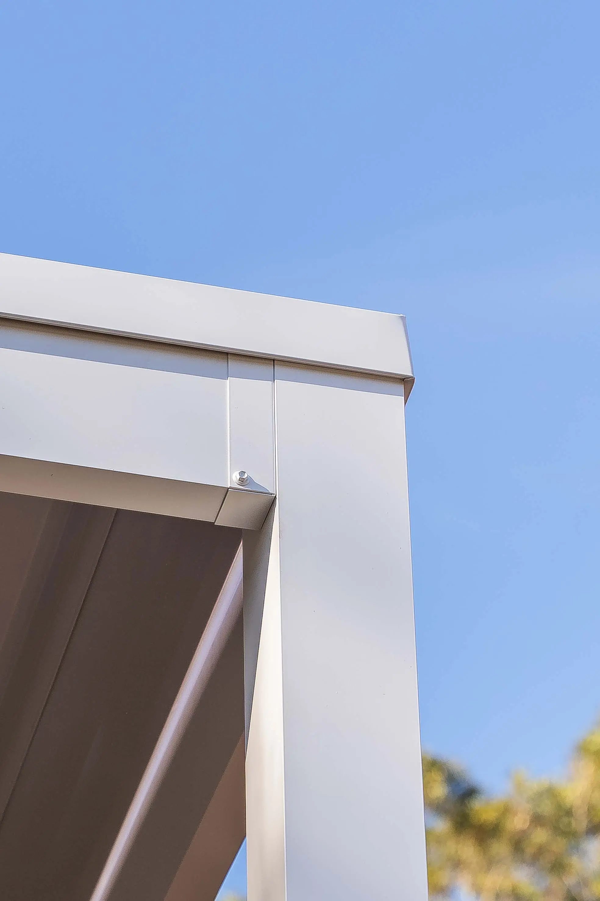 Upright view of square posts supporting the carport beam line